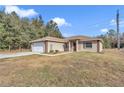 Tan house with white garage door and brown door at 3 Locust Trak, Ocala, FL 34472