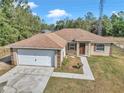 Single-story house with a white garage door and brown roof at 3 Locust Trak, Ocala, FL 34472