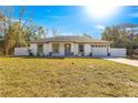 One-story home with gray trim and a white exterior at 3690 Se 133Rd Pl, Belleview, FL 34420