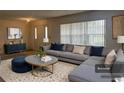 Bright living room featuring stylish gray sectional, patterned rug, and neutral decor at 5980 Se 4Th Pl, Ocala, FL 34472