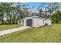 View of the home's side elevation, showcasing a gray garage door at 6068 Nw 57Th Ave, Ocala, FL 34482