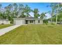 Newly built home featuring gray exterior, attached garage, and grassy front yard at 6088 Nw 57Th Ave, Ocala, FL 34482