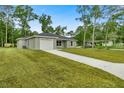 Gray house with a white garage door and a large grassy yard at 6088 Nw 57Th Ave, Ocala, FL 34482