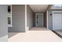 Front entrance with light gray door and gray siding at 6267 Sw 75Th Court Rd, Ocala, FL 34474