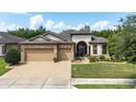 Two-story house with a three-car garage and landscaped lawn at 7646 Sw 100Th Ct, Ocala, FL 34481