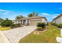 One-story home with landscaped yard, paver driveway and two-car garage at 7977 Sw 85Th Loop, Ocala, FL 34476