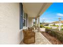 Relaxing front porch with wicker chairs and brick flooring at 7977 Sw 85Th Loop, Ocala, FL 34476