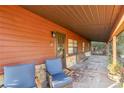 Covered porch with stone base, two blue armchairs, and potted plants at 876 Ne 71St Ln, Ocala, FL 34479