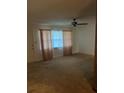 Bright living room featuring neutral carpeting and a ceiling fan at 9359 Bahia Rd, Ocala, FL 34472