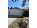 House exterior showcasing a two car garage and well maintained lawn at 9794 Sw 96Th St, Ocala, FL 34481