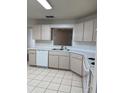 Galley style kitchen with white cabinets and tile flooring at 9794 Sw 96Th St, Ocala, FL 34481