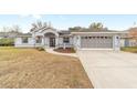 Two-car garage and gray house exterior with driveway at 10628 Sw 74Th Ave, Ocala, FL 34476