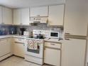 Kitchen with white cabinets, modern appliances, and tile backsplash at 10800 Sw 62Nd Ave, Ocala, FL 34476