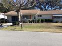 Front view of a ranch-style home with a well-maintained lawn at 10829 Sw 83Rd Ave, Ocala, FL 34481