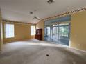 Spacious main bedroom with carpet flooring, ceiling fan, and sliding doors leading to a sunroom at 11577 Sw 72Nd Cir, Ocala, FL 34476