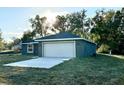 New home with gray siding, white garage door, and a paved driveway at 13380 Se 43Rd Ave, Belleview, FL 34420