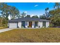 Modern home with white exterior, gray roof, and a two-car garage at 14363 Se 36Th Ct, Summerfield, FL 34491