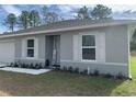 Gray house with white shutters, landscaping, and a small front yard at 15155 Sw 52 Cir, Ocala, FL 34473