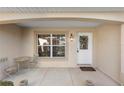 Covered front porch with seating area and a white door at 1982 Somerset Ave, The Villages, FL 32162