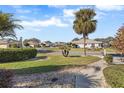 Landscaped front yard with palm trees and a walkway at 1982 Somerset Ave, The Villages, FL 32162