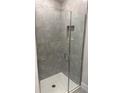 Modern shower featuring gray tiling, glass doors, a white shower base, and integrated shelves at 2158 Nw 23Rd Loop, Ocala, FL 34475