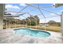 Kidney-shaped pool with a screened enclosure and stone deck at 2883 Sw 66Th St, Ocala, FL 34476