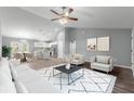 Open concept living area with a modern aesthetic, featuring a white couch and gray walls at 7084 Se 124 St, Belleview, FL 34420