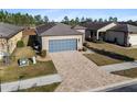 One-story house with gray garage door and paver driveway; aerial view at 7752 Sw 96Th Avenue Rd, Ocala, FL 34481