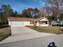 Bright yellow house with red door and attached garage at 8623 Sw 108Th Place Rd, Ocala, FL 34481