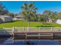 Large backyard with canal access, dock, and white picket fence at 11418 Lake Eustis Dr, Leesburg, FL 34788