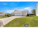 Traditional home with a brick driveway, a well-manicured front lawn, and an attached two-car garage at 2630 Dunbar Ave, The Villages, FL 32162