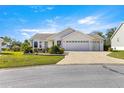 Traditional single story home with a brick driveway, an attached garage and well-maintained front lawn at 2630 Dunbar Ave, The Villages, FL 32162