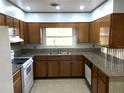 Traditional eat-in kitchen featuring wooden cabinets, granite counters, and modern white appliances at 691 Se 19Th St, Ocala, FL 34471