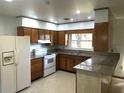 Traditional kitchen featuring wooden cabinets, granite counters, and modern white appliances at 691 Se 19Th St, Ocala, FL 34471