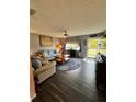 Living room with wood-look floors, sofas, and large window at 7632 Sw 112Th Ln, Ocala, FL 34476