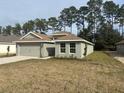 Newly built home showcasing a neutral color palette and a spacious front yard at 7661 Sw 180Th Cir, Dunnellon, FL 34432
