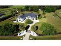 Large home with a circular drive, mature landscaping, and a secure gate, all surrounded by black fencing at 9340 Sw 9Th Ter, Ocala, FL 34476
