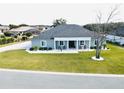 Single-story home with gray siding, gray roof, and a large front yard at 9645 Se 61St Ter, Belleview, FL 34420