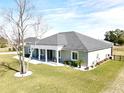 Single-story home with gray siding, gray roof, and a screened porch at 9645 Se 61St Ter, Belleview, FL 34420