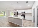 Modern kitchen with white cabinets, granite countertops, and stainless steel appliances at 10120 Se 130Th St, Belleview, FL 34420