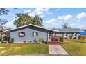 Gray house with metal roof, landscaped yard, and lake view at 10455 Se 143Rd St, Summerfield, FL 34491