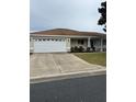 Exterior view of a single-story house with a two-car garage and driveway at 13981 Se 86Th Cir, Summerfield, FL 34491