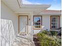 Inviting front porch with a white door and landscaping at 17385 Se 110Th Ter, Summerfield, FL 34491