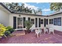 Brick courtyard with white metal chairs and lush greenery at 1758 Se 7Th St, Ocala, FL 34471