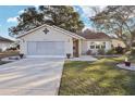 Tan one story house with a screened garage and small front yard at 1904 Tweed Ct, Leesburg, FL 34788