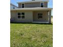 View of the home's backyard with green grass and a covered patio area at 2210 Nw 23Rd Loop, Ocala, FL 34475