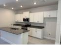 Modern kitchen with white cabinets, stainless steel appliances, granite countertops and a kitchen island at 2210 Nw 23Rd Loop, Ocala, FL 34475