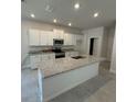 Modern kitchen featuring granite countertops, white cabinetry, stainless steel appliances, and an island with a sink at 2214 Nw 23Rd Loop, Ocala, FL 34475