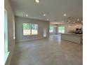 Spacious living area with tile flooring, neutral paint, and abundant natural light, seamlessly flowing into the kitchen at 2214 Nw 23Rd Loop, Ocala, FL 34475