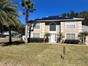 Two-story house with solar panels, palm trees, and well-maintained lawn at 4517 Se 28Th St, Ocala, FL 34480